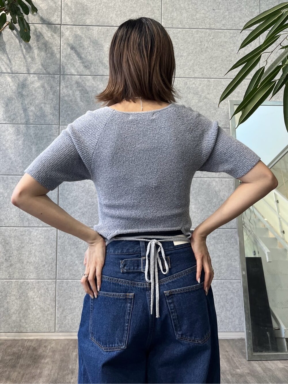 ブルー系のニット/セーター、ブルー系のデニムパンツ、ブラック系のサンダルを着用したレディースの冬コーディネートの7枚目の写真