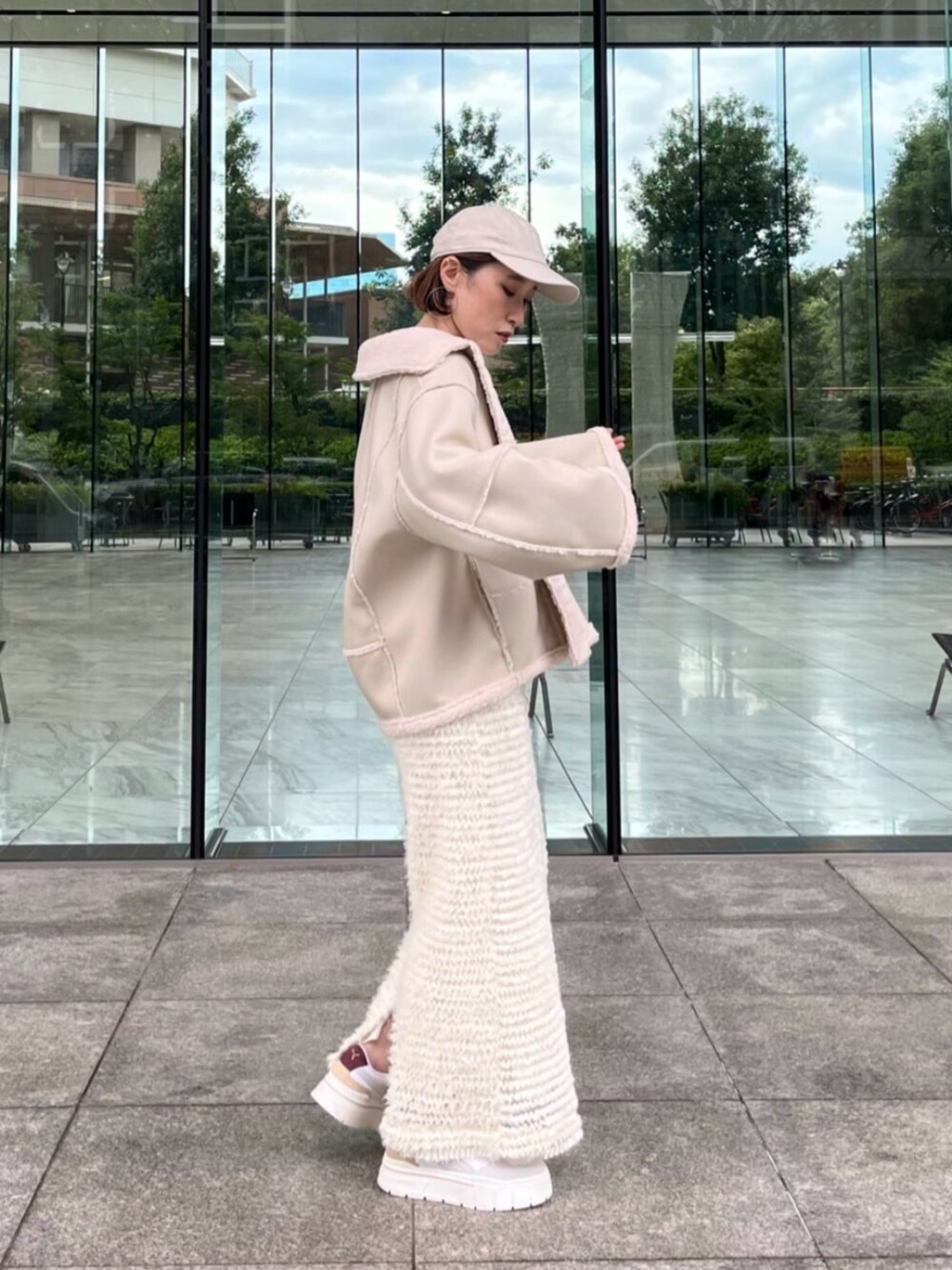 ホワイト系のスカート、ホワイト系のブルゾン、ホワイト系のTシャツ/カットソーを着用したレディースの秋コーディネートの2枚目の写真