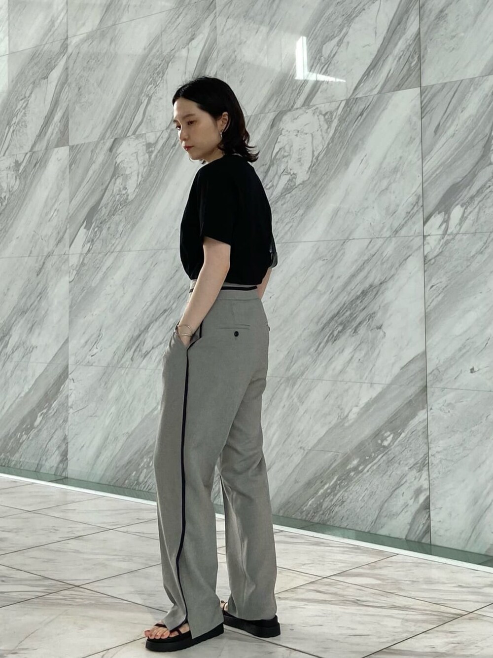 グレー系のその他パンツ、ブラック系のサンダル、ブラック系のTシャツ/カットソーを着用したレディースの夏コーディネートの3枚目の写真