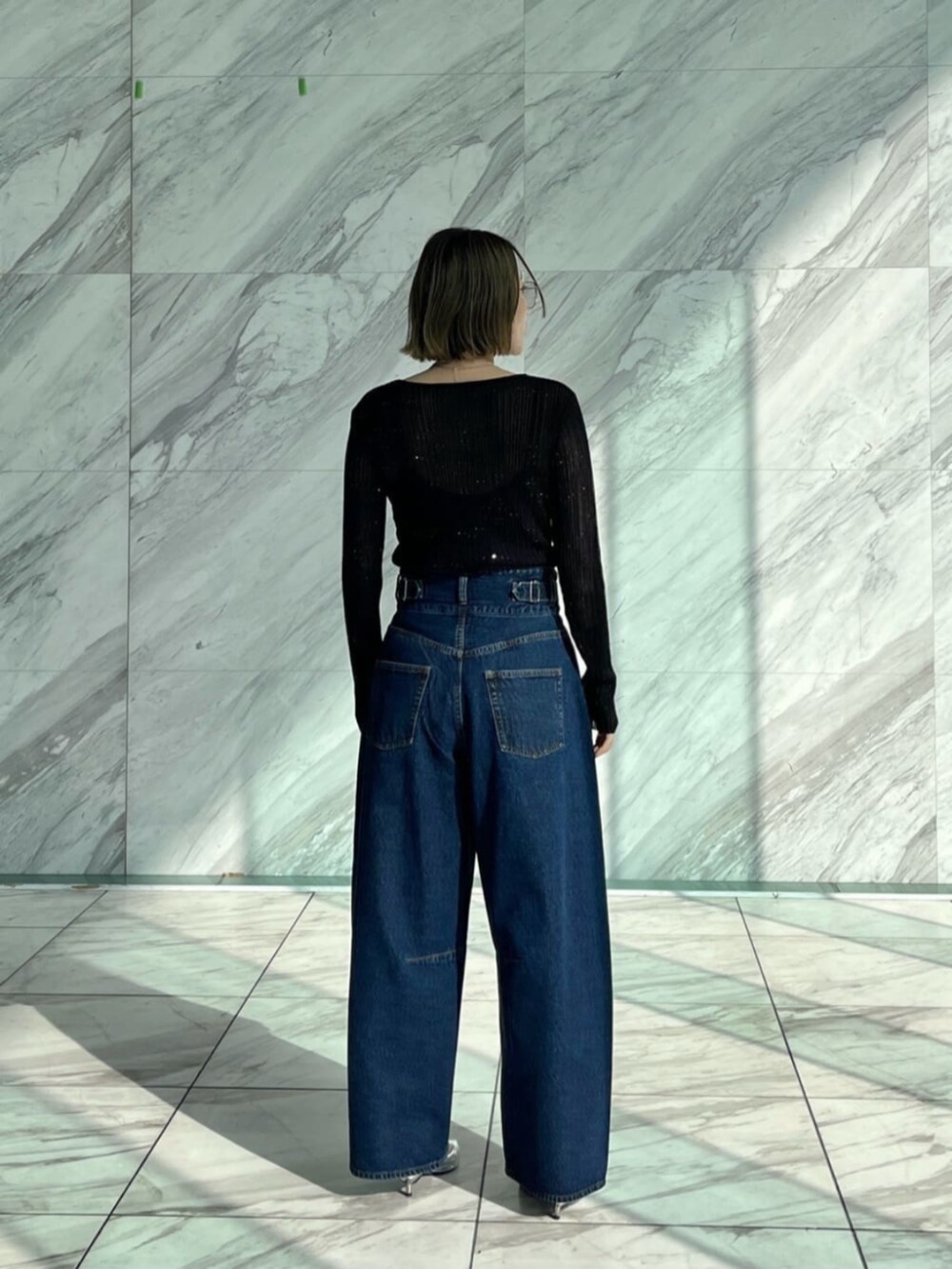 ブルー系のデニムパンツ、ブラック系のニット/セーターを着用したレディースの冬コーディネートの4枚目の写真