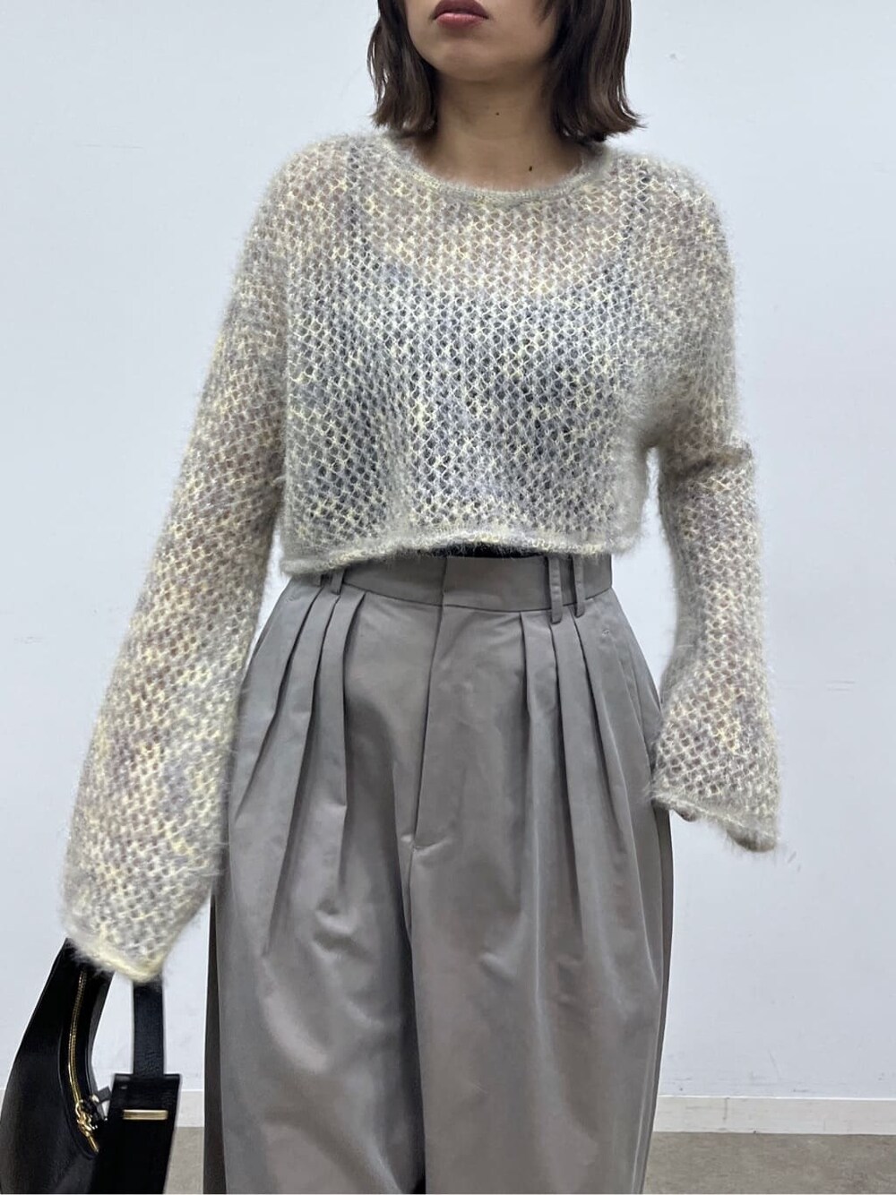ベージュ系のニット/セーター、グレー系のその他パンツ、ブラック系のショルダーバッグを着用したレディースの冬コーディネートの6枚目の写真