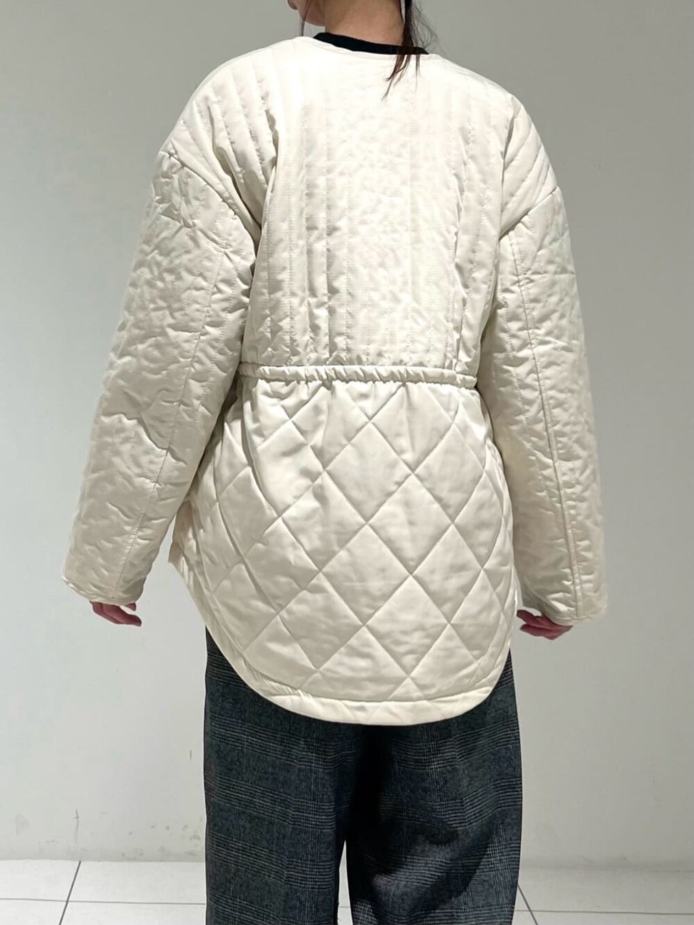 ホワイト系のその他アウター、グレー系のその他パンツ、ブラック系のニット/セーターを着用したレディースの冬コーディネートの5枚目の写真