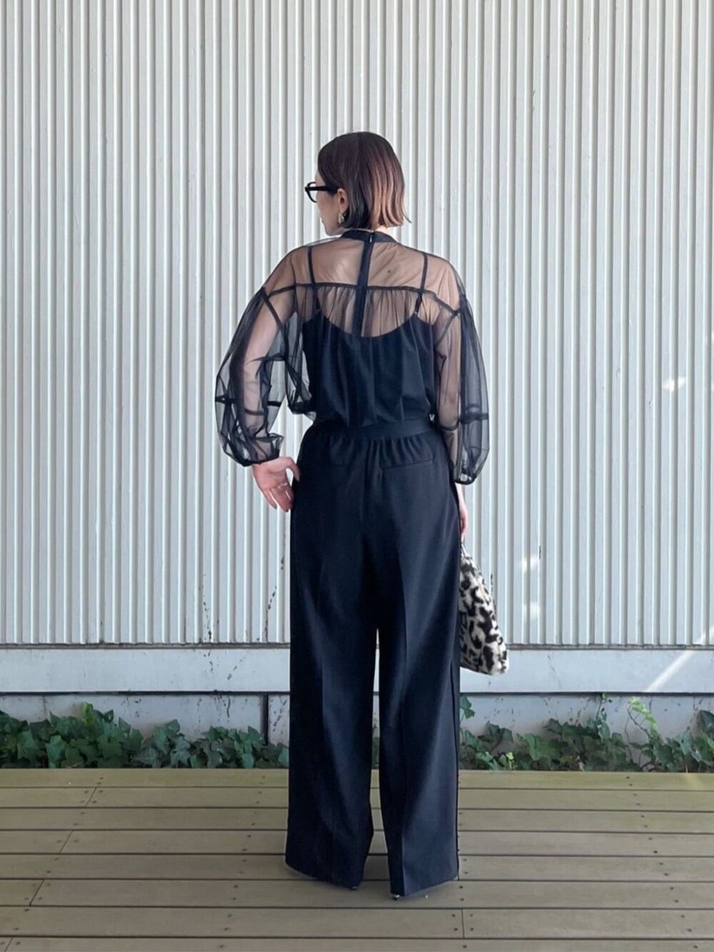 ブラック系のシャツ/ブラウス、ブラック系のその他パンツ、ブラウン系のハンドバッグを着用したレディースの秋コーディネートの5枚目の写真