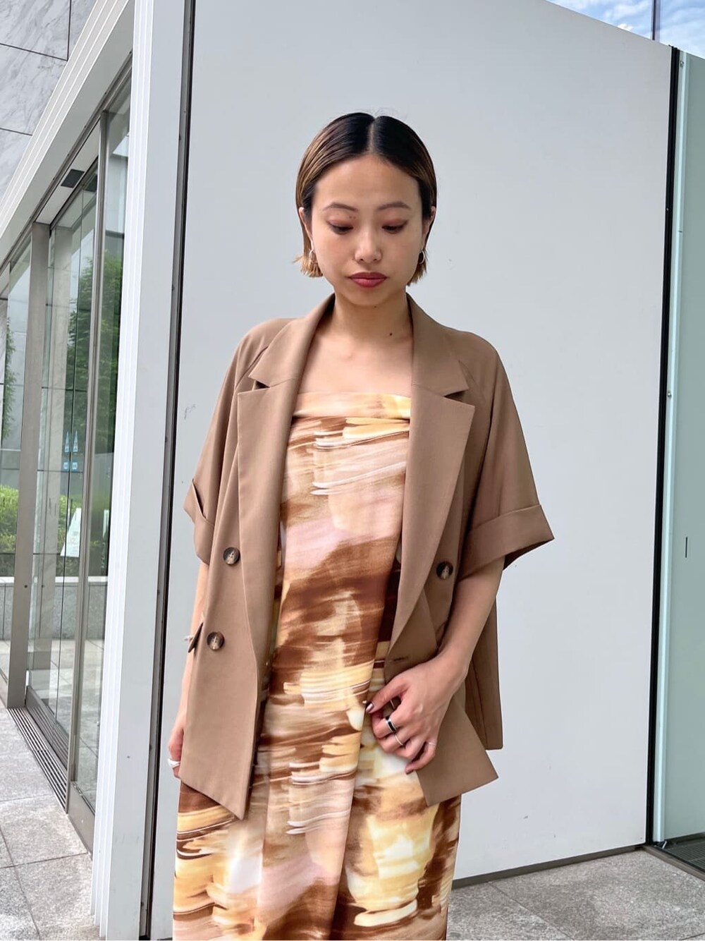 イエロー系のテーラードジャケット、イエロー系のワンピースを着用したレディースの夏コーディネートの5枚目の写真