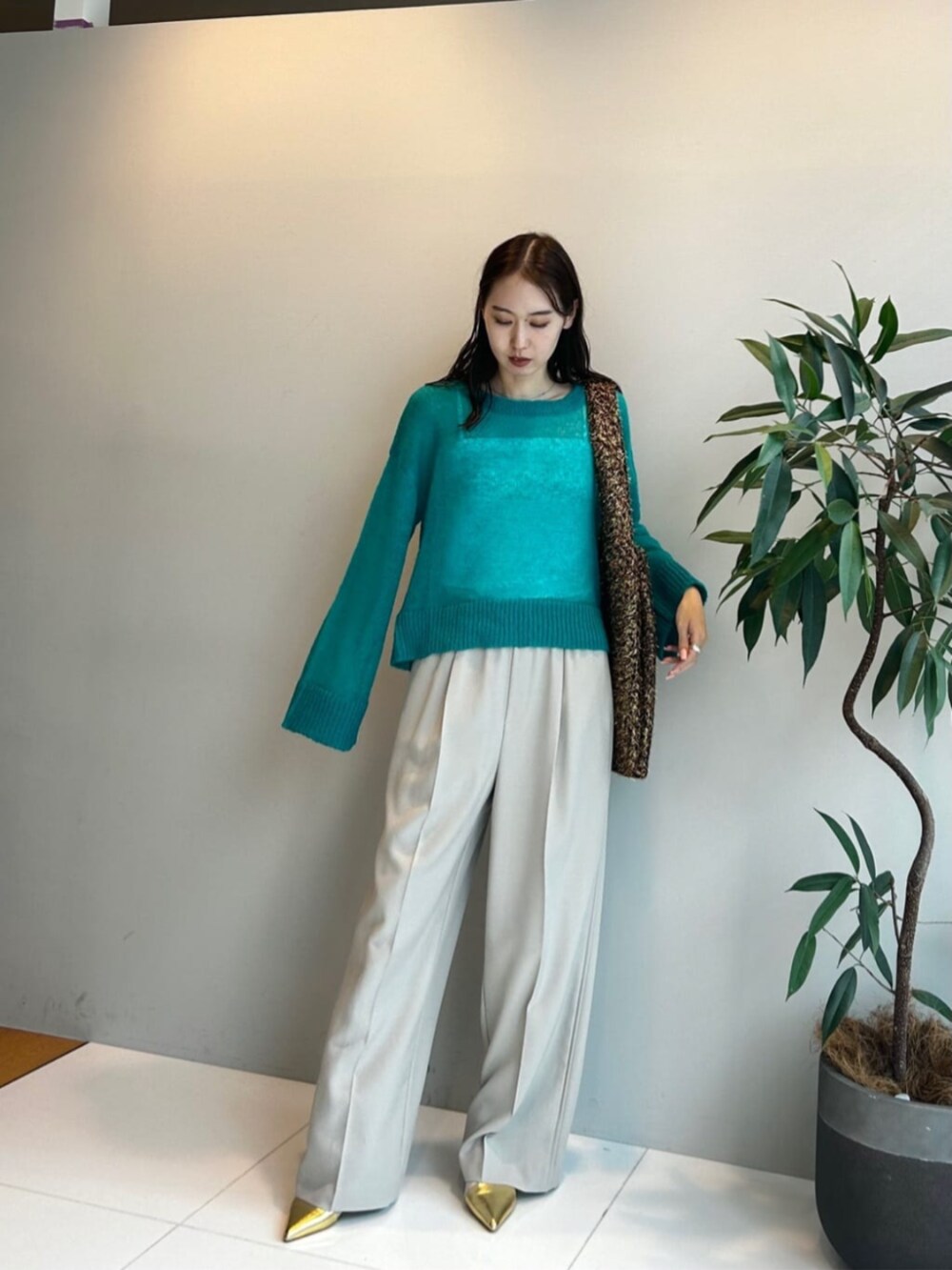 ゴールド系のトートバッグ、ブルー系のニット/セーター、ベージュ系のその他パンツを着用したレディースの秋コーディネートの4枚目の写真