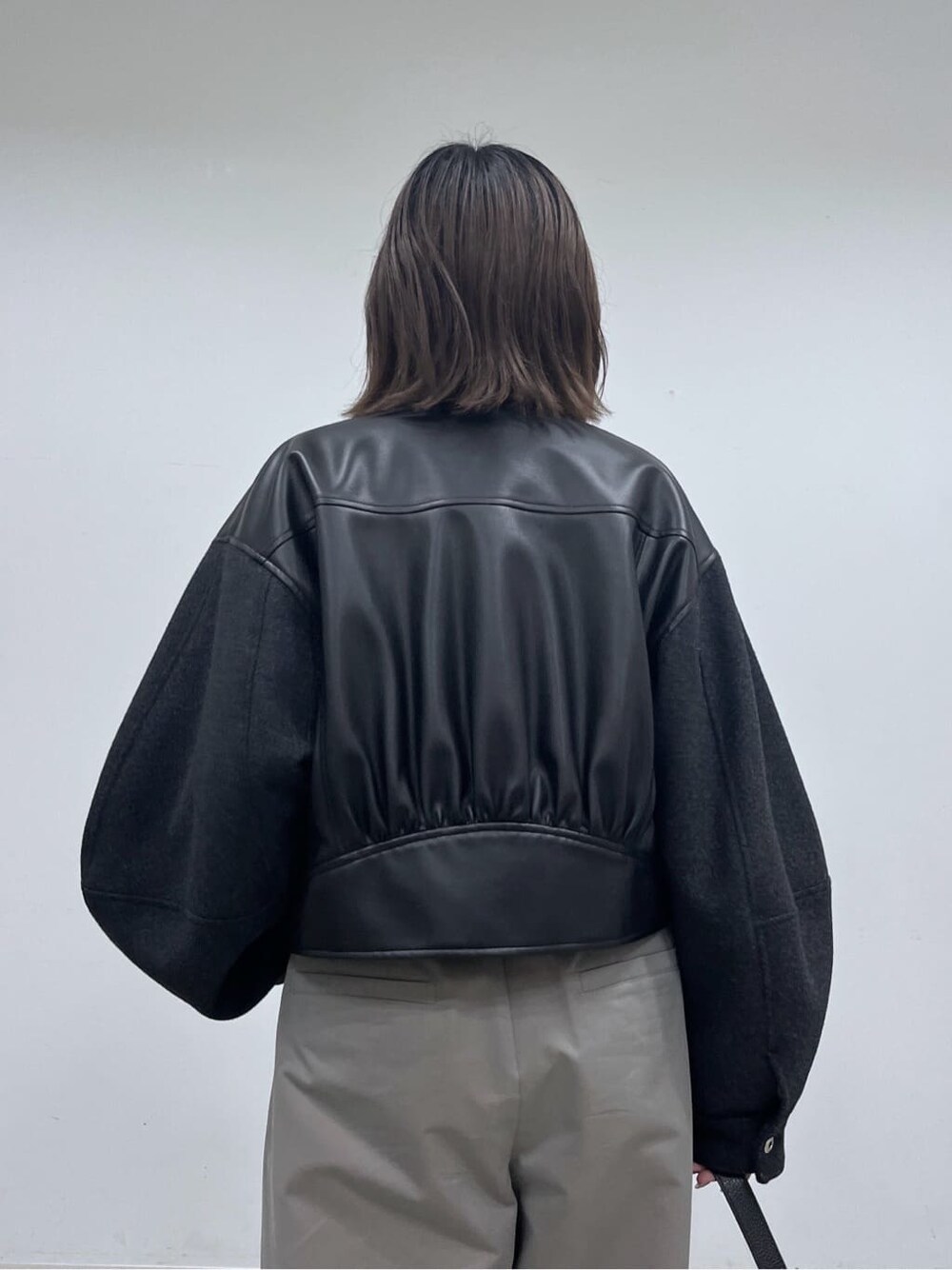 ブラック系のブルゾン、ベージュ系のニット/セーター、グレー系のその他パンツを着用したレディースの冬コーディネートの8枚目の写真