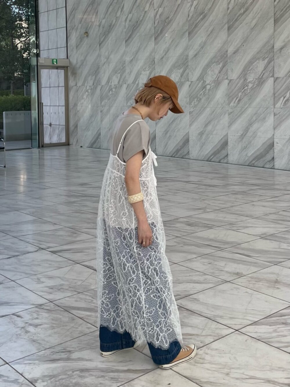 ブルー系のデニムパンツ、グレー系のTシャツ/カットソー、ホワイト系のワンピースを着用したレディースの春コーディネートの3枚目の写真