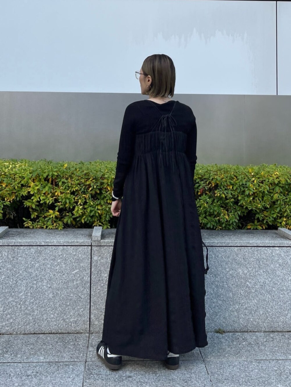 ブラック系のニット/セーター、ブラック系のワンピースを着用したレディースの春コーディネートの4枚目の写真