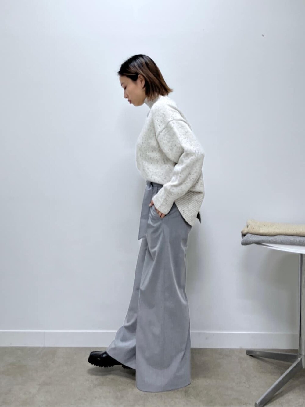 ホワイト系のニット/セーター、グレー系のその他パンツを着用したレディースの冬コーディネートの2枚目の写真