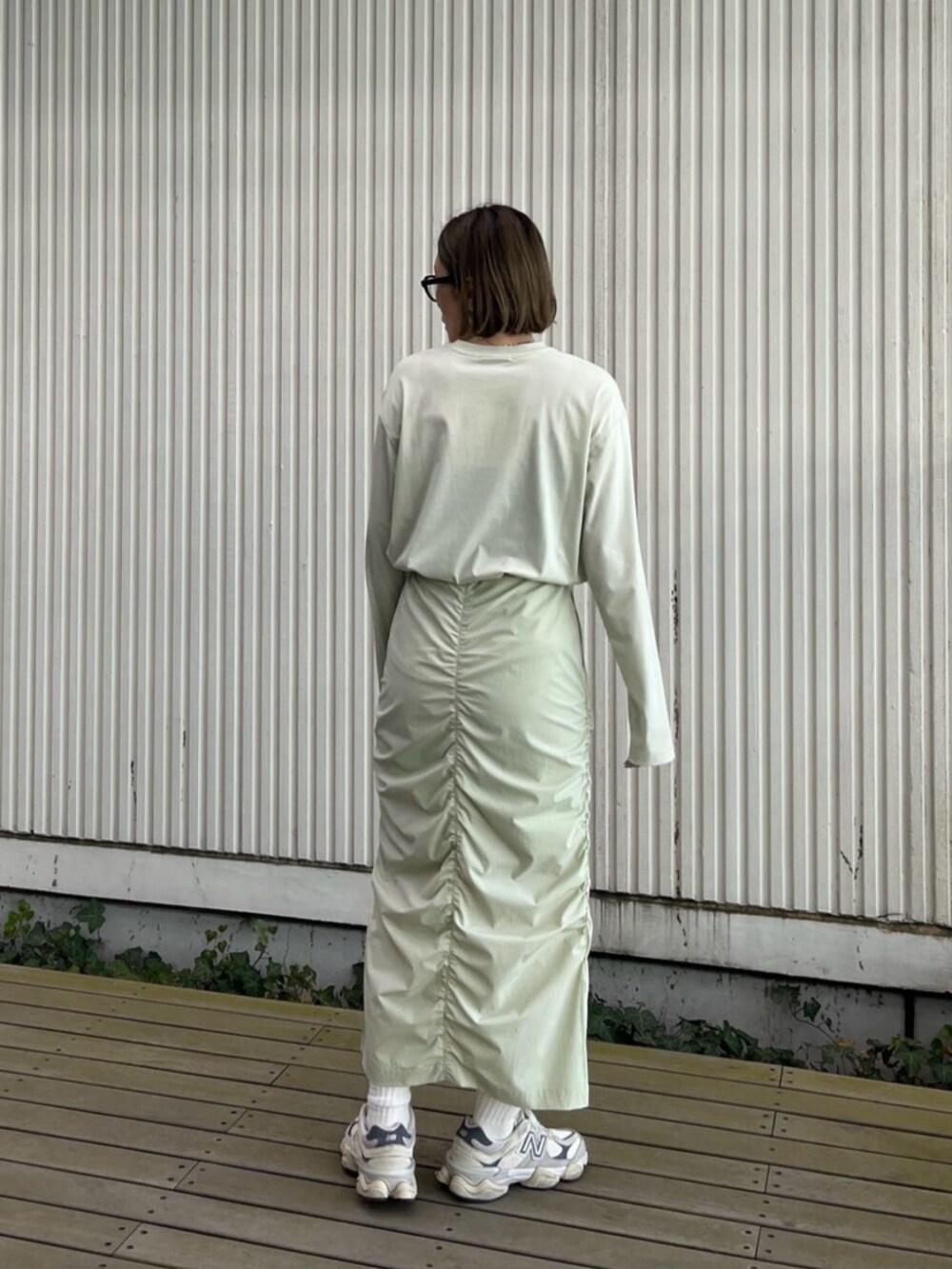 グリーン系のスカート、グリーン系のTシャツ/カットソーを着用したレディースの冬コーディネートの2枚目の写真