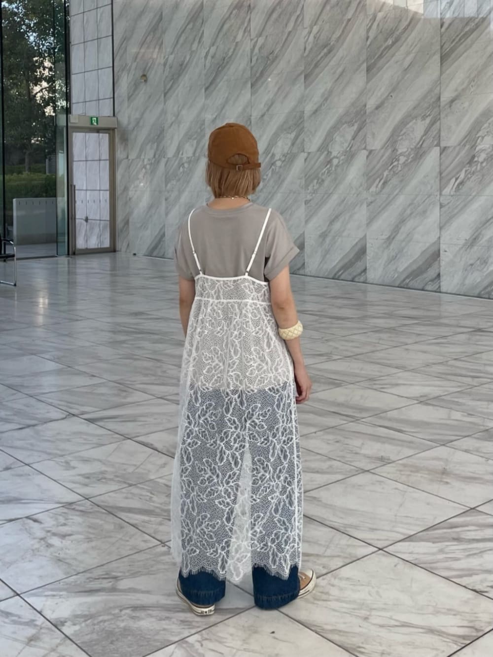 ブルー系のデニムパンツ、グレー系のTシャツ/カットソー、ホワイト系のワンピースを着用したレディースの春コーディネートの4枚目の写真