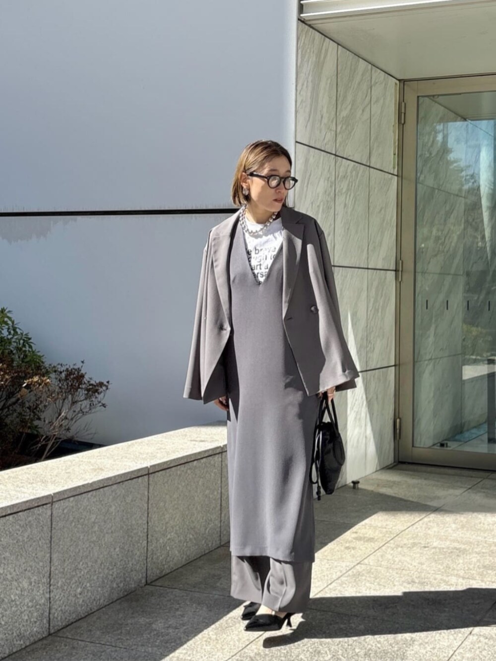 グレー系のその他パンツ、グレー系のワンピース、ホワイト系のTシャツ/カットソーを着用したレディースの春コーディネートの3枚目の写真