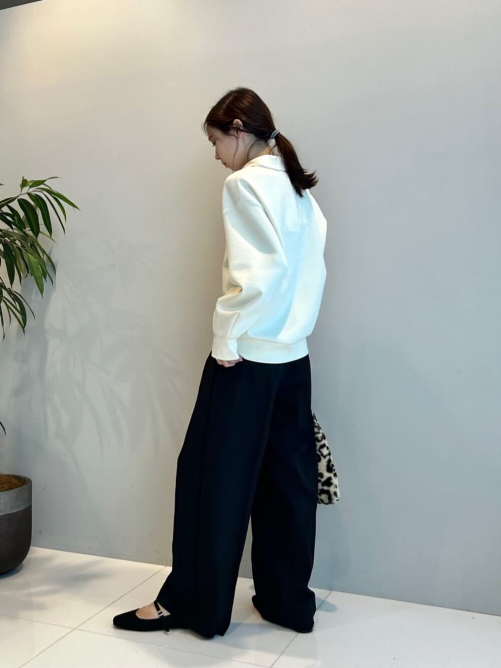 ブラウン系のハンドバッグ、ブラック系のその他パンツ、ホワイト系のTシャツ/カットソーを着用したレディースの秋コーディネートの3枚目の写真