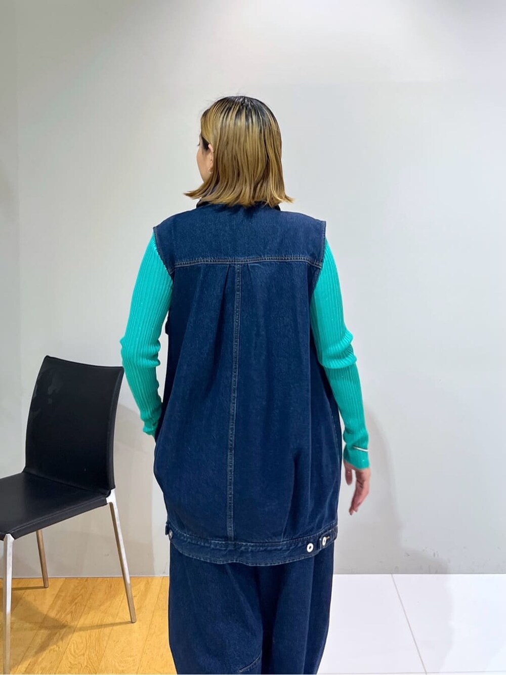 ブルー系のデニムジャケット、グリーン系のニット/セーター、ブルー系のデニムパンツを着用したレディースの冬コーディネートの7枚目の写真