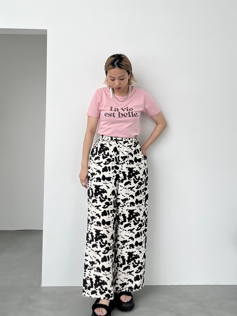 ピンク系のTシャツ/カットソー、ベージュ系のその他パンツ、ブラック系のサンダルを着用したレディースの夏コーディネートの8枚目の写真