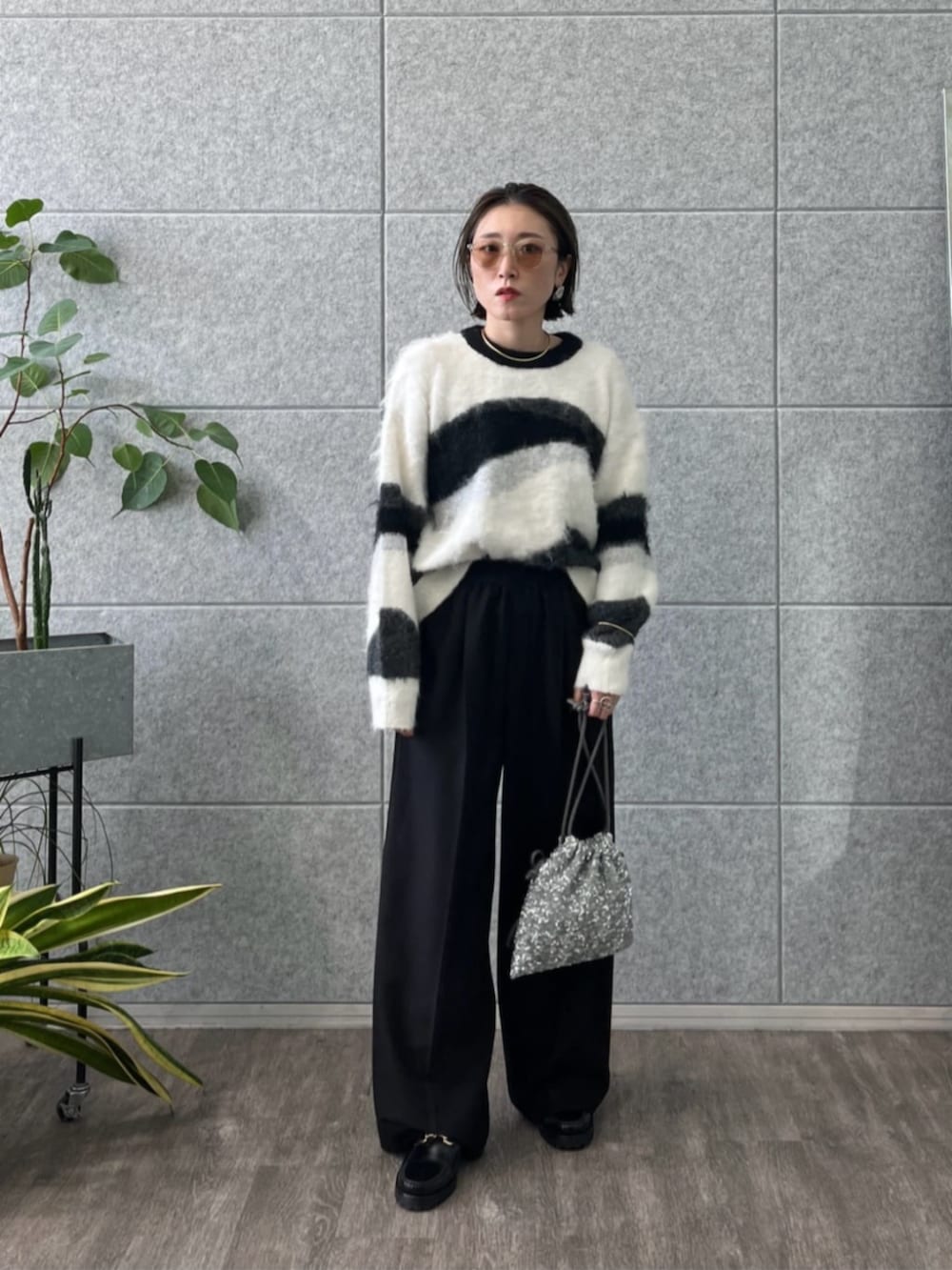 シルバー系のショルダーバッグ、グレー系のニット/セーター、ブラック系のその他パンツを着用したレディースの冬コーディネートの4枚目の写真