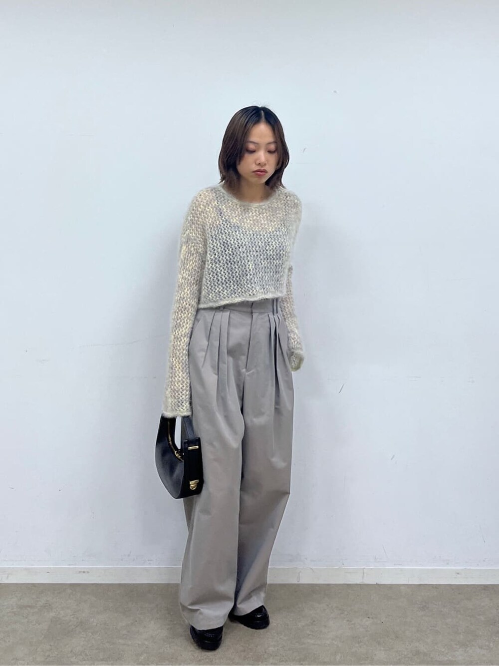 ベージュ系のニット/セーター、グレー系のその他パンツ、ブラック系のショルダーバッグを着用したレディースの冬コーディネートの9枚目の写真