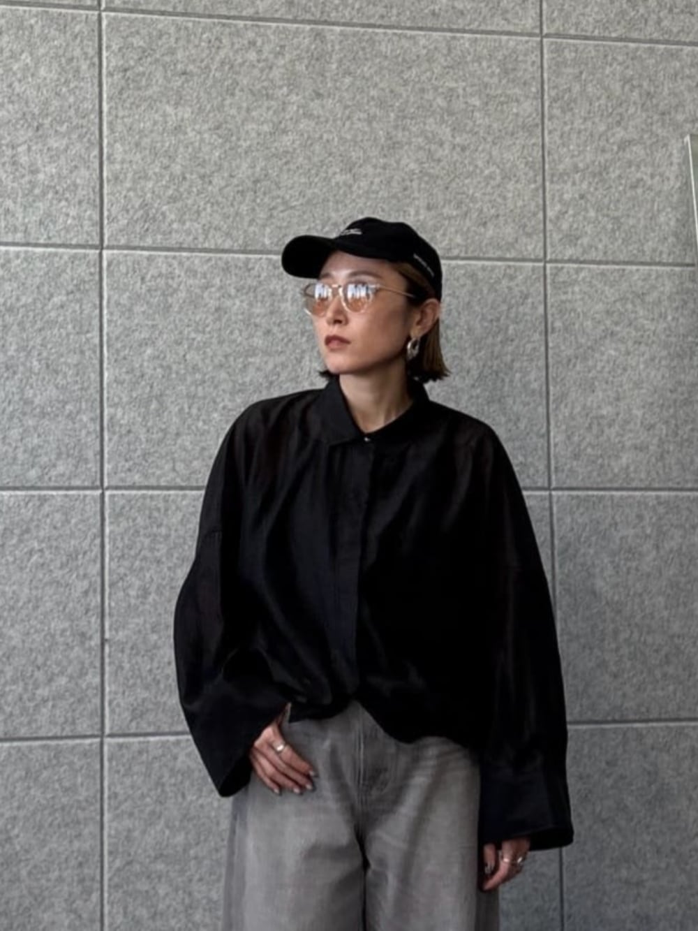 グレー系のデニムパンツ、ブラック系のシャツ/ブラウスを着用したレディースの春コーディネートの5枚目の写真