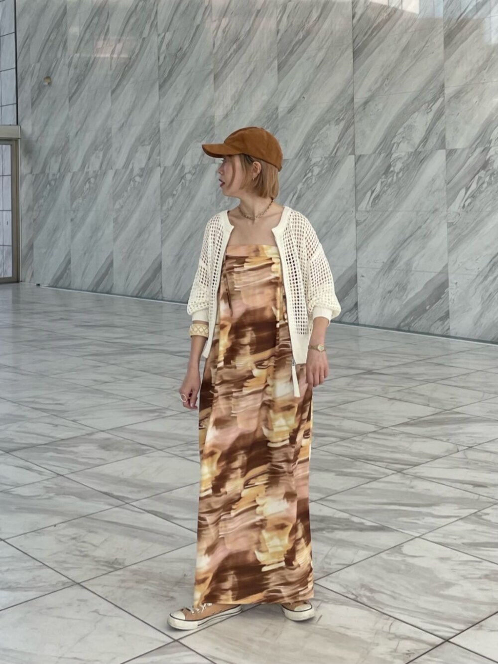 イエロー系のワンピース、ホワイト系のカーディガン/ボレロを着用したレディースの春コーディネートの2枚目の写真