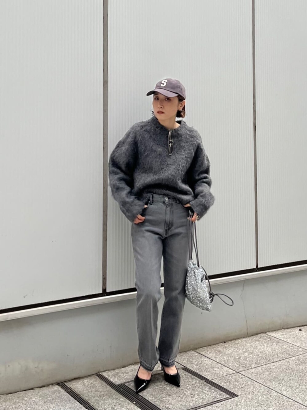 シルバー系のショルダーバッグ、グレー系のデニムパンツ、グレー系のニット/セーターを着用したレディースの秋コーディネートの2枚目の写真