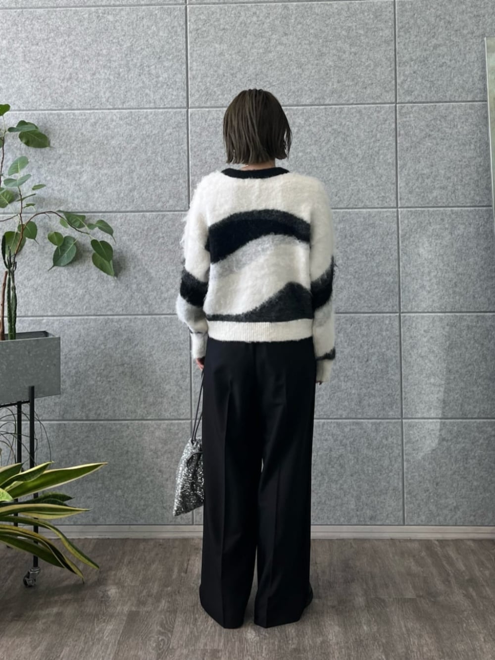 シルバー系のショルダーバッグ、グレー系のニット/セーター、ブラック系のその他パンツを着用したレディースの冬コーディネートの2枚目の写真