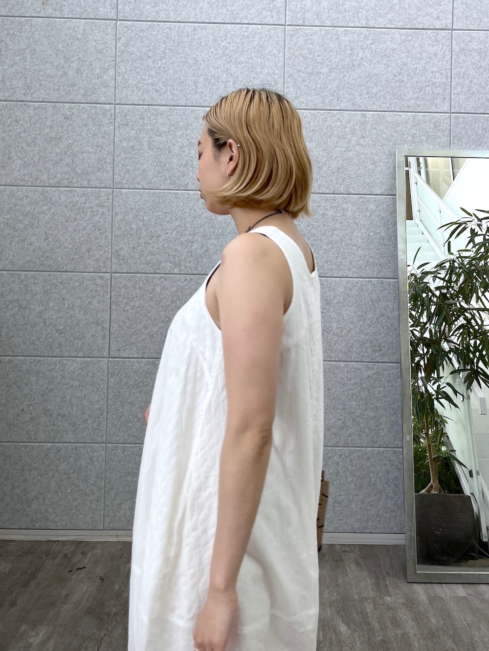 ホワイト系のワンピース、ブラック系のトートバッグ、シルバー系のサンダルを着用したレディースの夏コーディネートの6枚目の写真