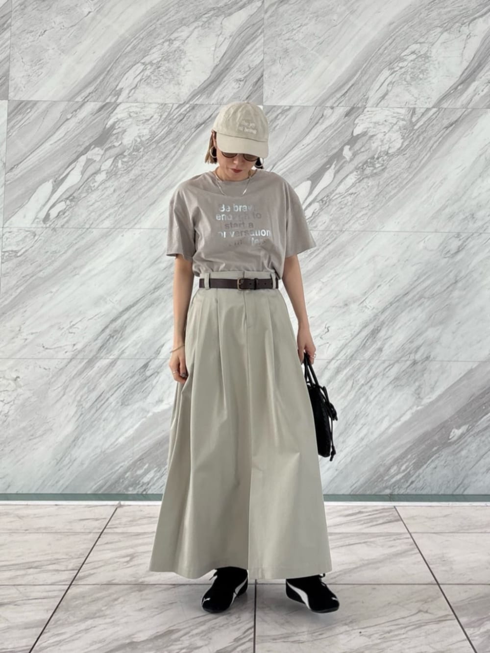 グリーン系のスカート、グレー系のTシャツ/カットソーを着用したレディースの春コーディネートの2枚目の写真