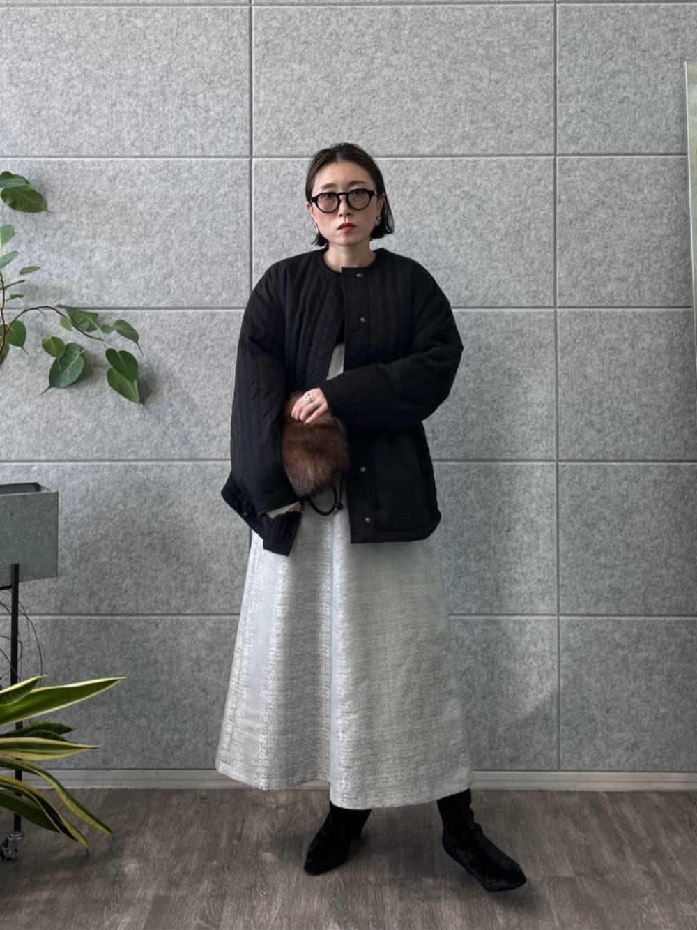 ブラック系のブーツ、ブラック系のその他アウター、グレー系のスカートを着用したレディースの冬コーディネートの4枚目の写真