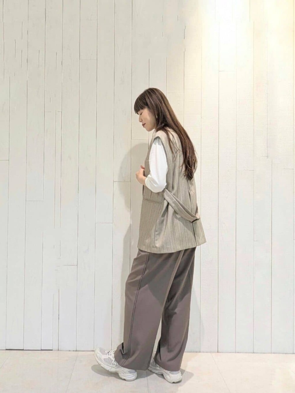 ブラウン系のその他パンツ、ベージュ系のベスト、ホワイト系のTシャツ/カットソーを着用したレディースの秋コーディネートの2枚目の写真