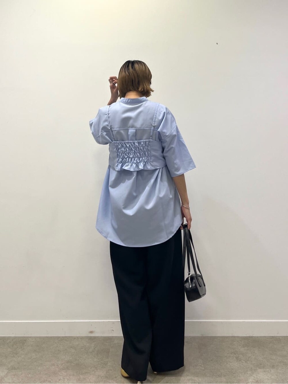 ブルー系のシャツ/ブラウス、ブラック系のその他パンツ、ブラック系のハンドバッグを着用したレディースの夏コーディネートの4枚目の写真