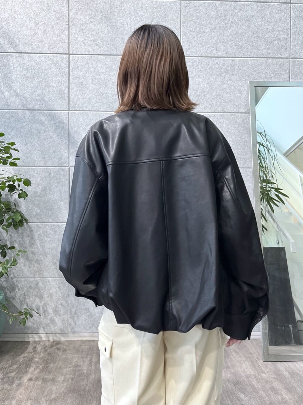 ブラック系のブルゾン、ブラック系のニット/セーター、ホワイト系のその他パンツを着用したレディースの秋コーディネートの8枚目の写真