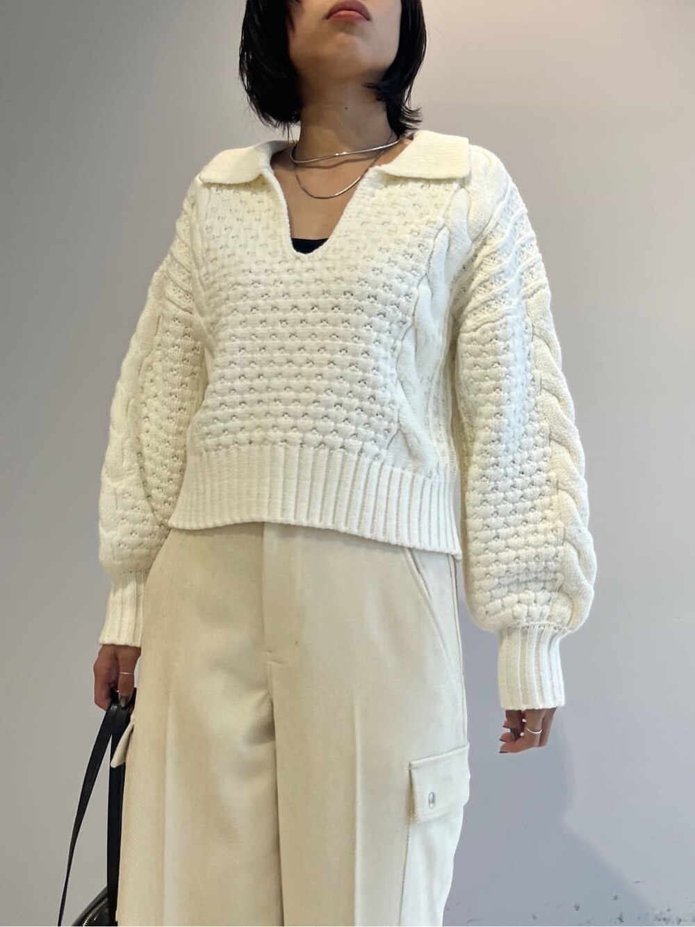 ホワイト系のニット/セーター、ホワイト系のその他パンツ、ブラック系のハンドバッグを着用したレディースの秋コーディネートの5枚目の写真