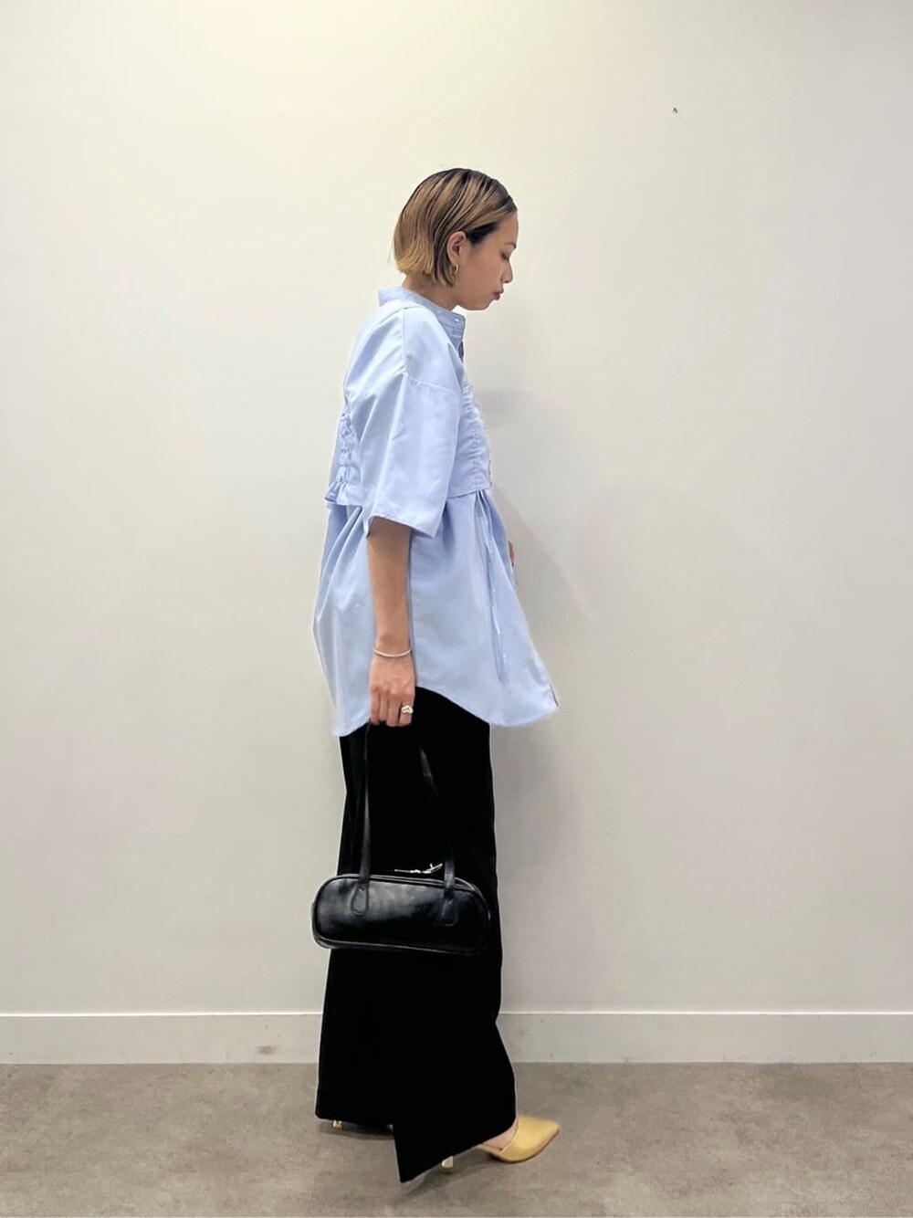 ブルー系のシャツ/ブラウス、ブラック系のその他パンツ、ブラック系のハンドバッグを着用したレディースの夏コーディネートの2枚目の写真