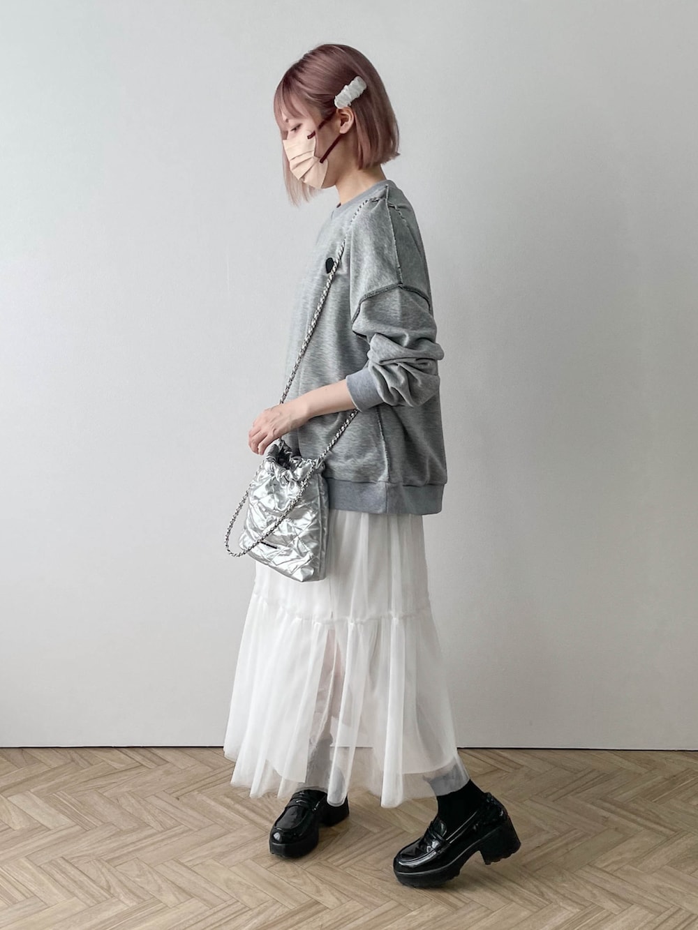 ホワイト系のスカート、グレー系のスウェットを着用したレディースの春コーディネートの2枚目の写真