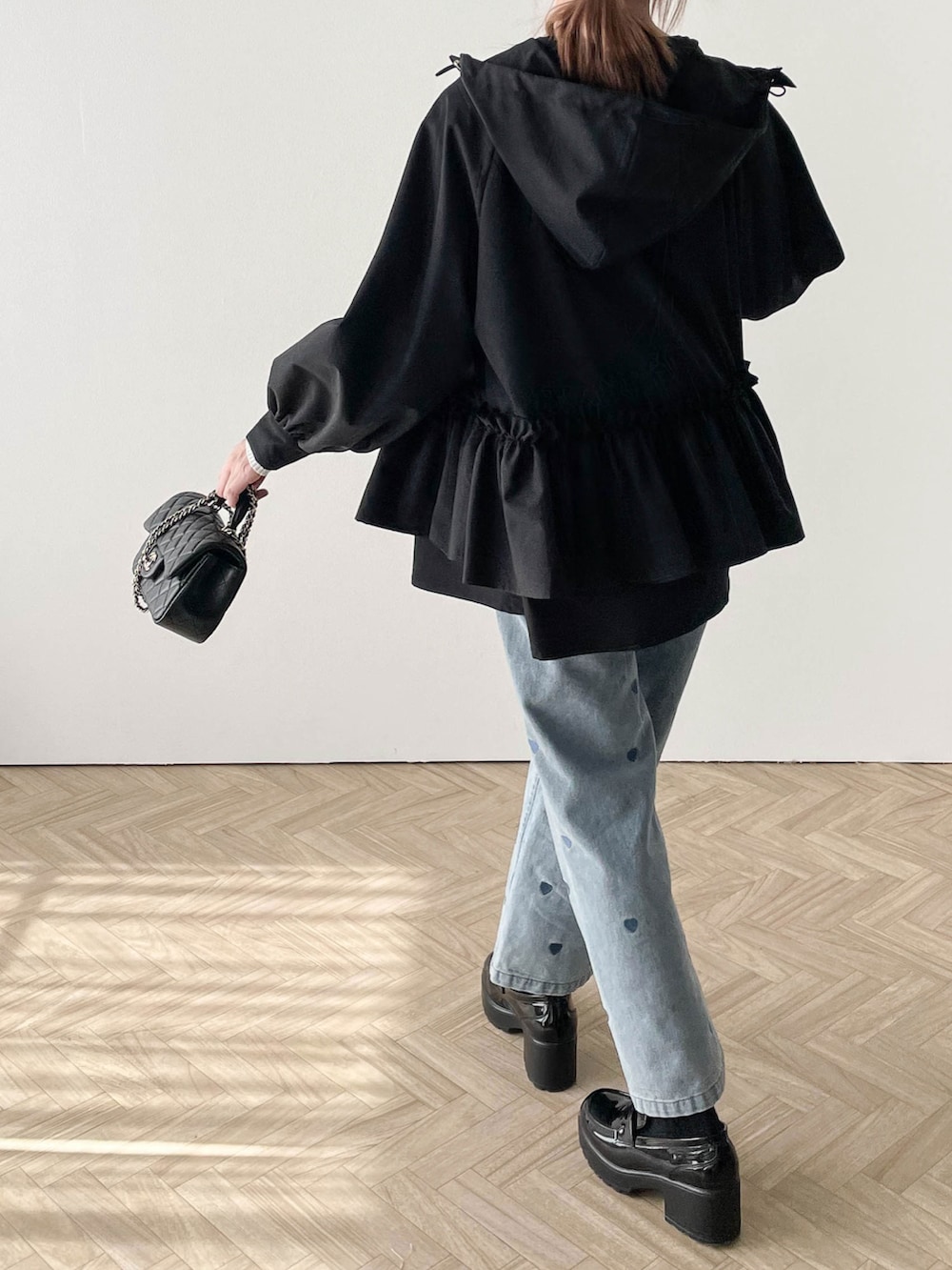 ブルー系のデニムパンツ、ブラック系のマウンテンパーカーを着用したレディースの春コーディネートの2枚目の写真