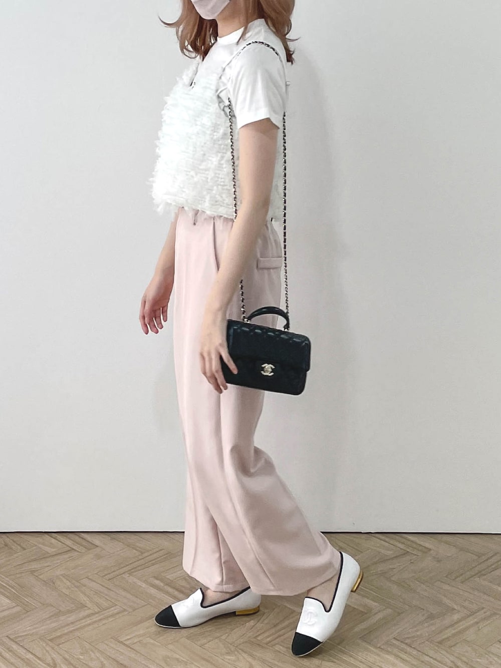 ピンク系のスラックス、ホワイト系のキャミソールを着用したレディースの春コーディネートの2枚目の写真