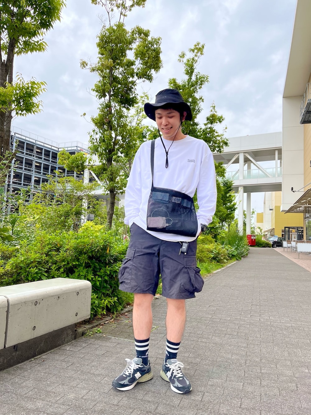 ホワイト系のTシャツ/カットソー、ブラック系のショルダーバッグ、ブラック系のカーゴパンツを着用したメンズの夏コーディネートの4枚目の写真