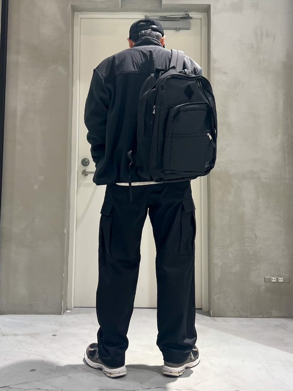 グレー系のスニーカー、ブラック系のカーゴパンツ、ホワイト系のTシャツ/カットソーを着用したメンズの秋コーディネートの2枚目の写真