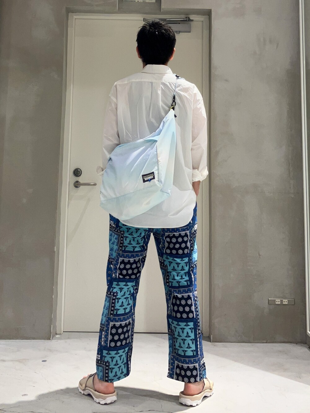 ブルー系のショルダーバッグ、ブルー系のその他パンツ、ホワイト系のシャツ/ブラウスを着用したメンズの夏コーディネートの2枚目の写真