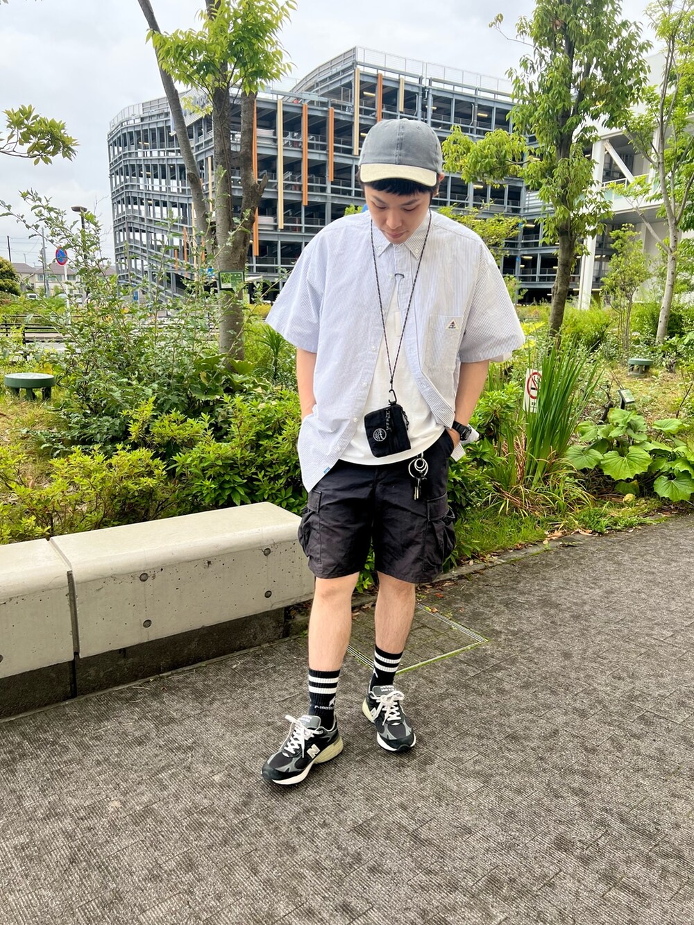 ブラック系のスニーカー、ブラック系のカーゴパンツ、ブラック系のショルダーバッグを着用したメンズの夏コーディネートの4枚目の写真