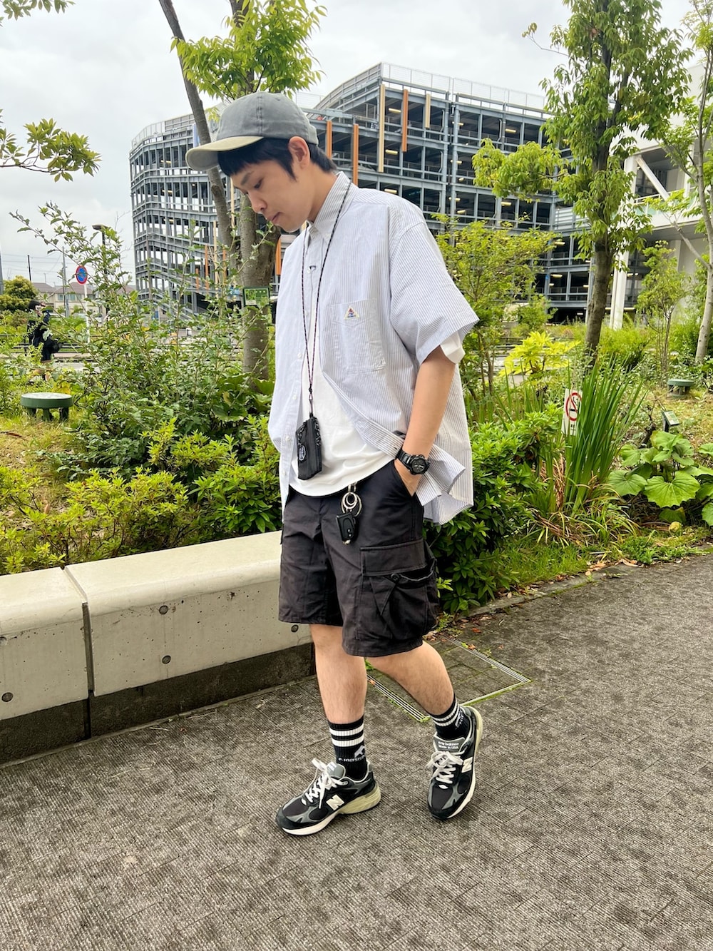 ブラック系のスニーカー、ブラック系のカーゴパンツ、ブラック系のショルダーバッグを着用したメンズの夏コーディネートの2枚目の写真