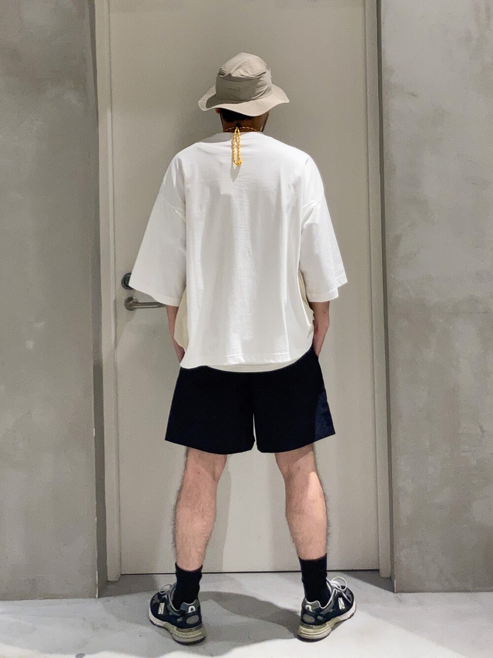 ブラック系のその他パンツ、ベージュ系のショルダーバッグ、ホワイト系のTシャツ/カットソーを着用したメンズの夏コーディネートの2枚目の写真