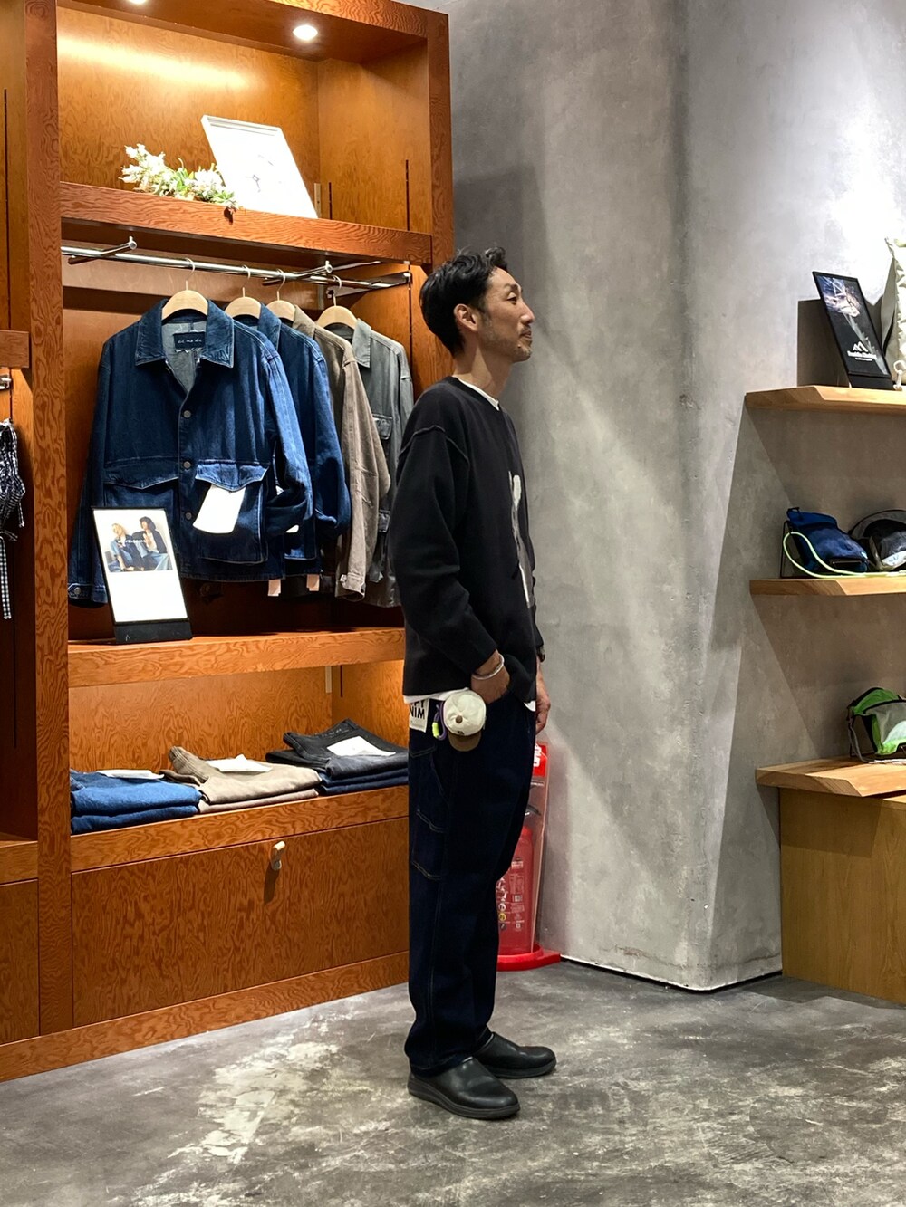 ブルー系のデニムパンツ、ブラック系のニット/セーターを着用したメンズの秋コーディネートの2枚目の写真