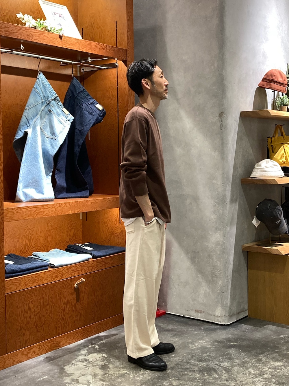 ブラウン系のニット/セーター、ホワイト系のその他パンツを着用したメンズの春コーディネートの2枚目の写真