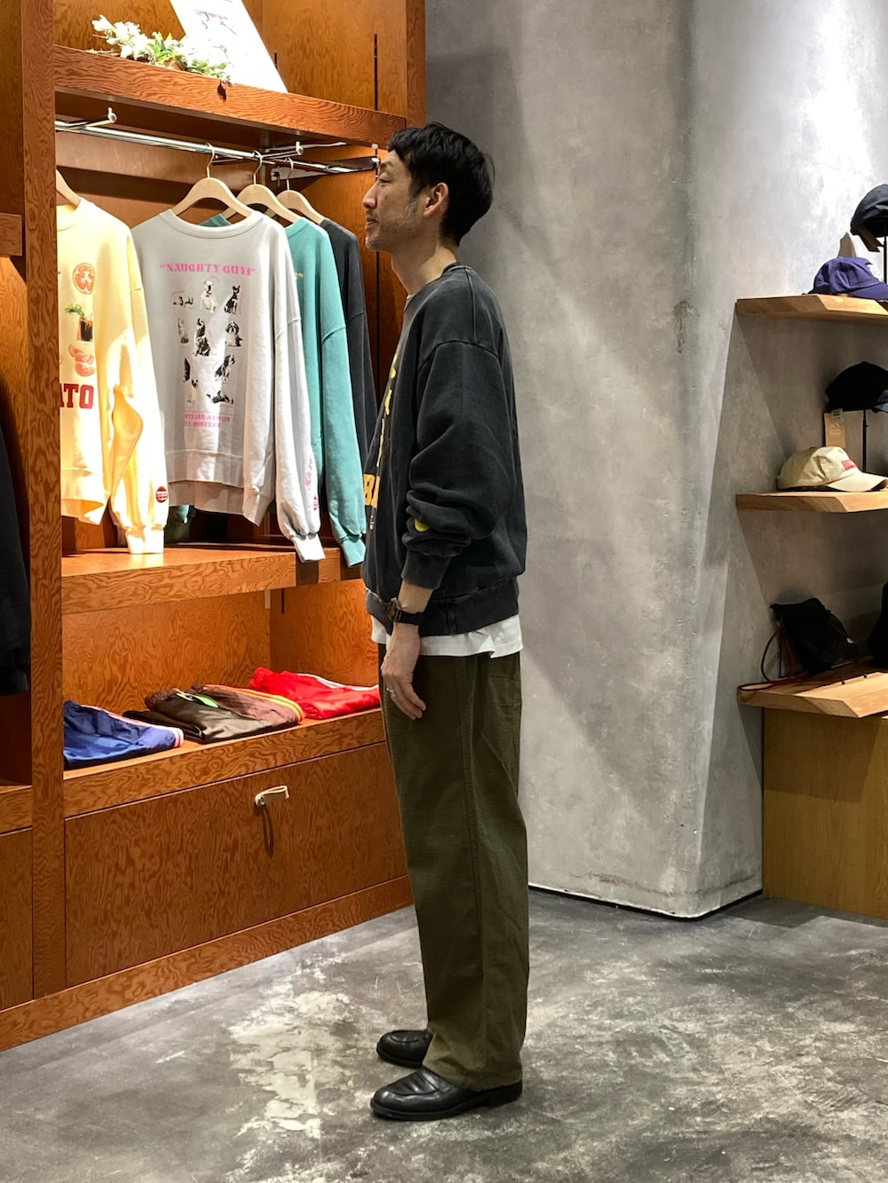 ブラック系のスウェット、グリーン系のカーゴパンツを着用したメンズの春コーディネートの2枚目の写真