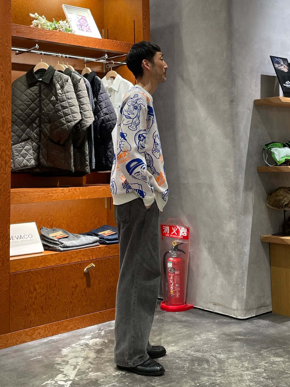 ホワイト系のニット/セーター、ブラック系のデニムパンツを着用したメンズの秋コーディネートの2枚目の写真