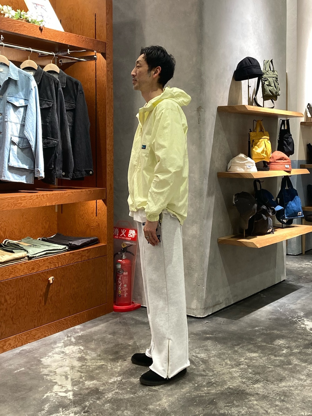 イエロー系のマウンテンパーカー、グレー系のスウェットパンツを着用したメンズの春コーディネートの2枚目の写真