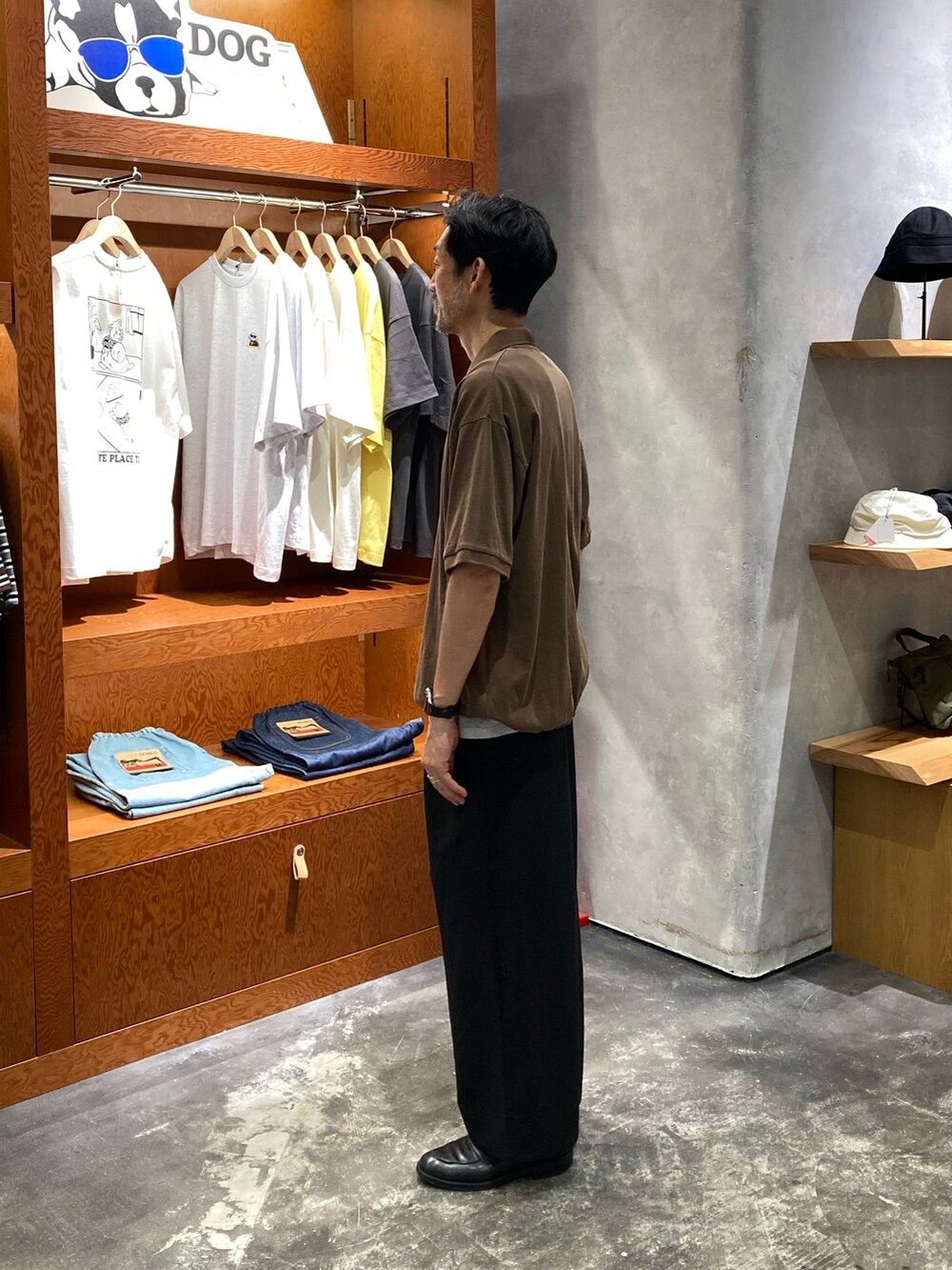 ブラウン系のポロシャツ、ブラック系のスラックス、グレー系のタンクトップを着用したメンズの夏コーディネートの2枚目の写真