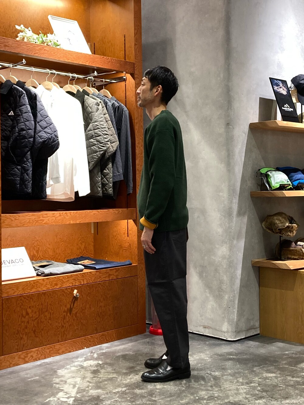 グリーン系のニット/セーター、ブラック系のその他パンツを着用したメンズの秋コーディネートの2枚目の写真