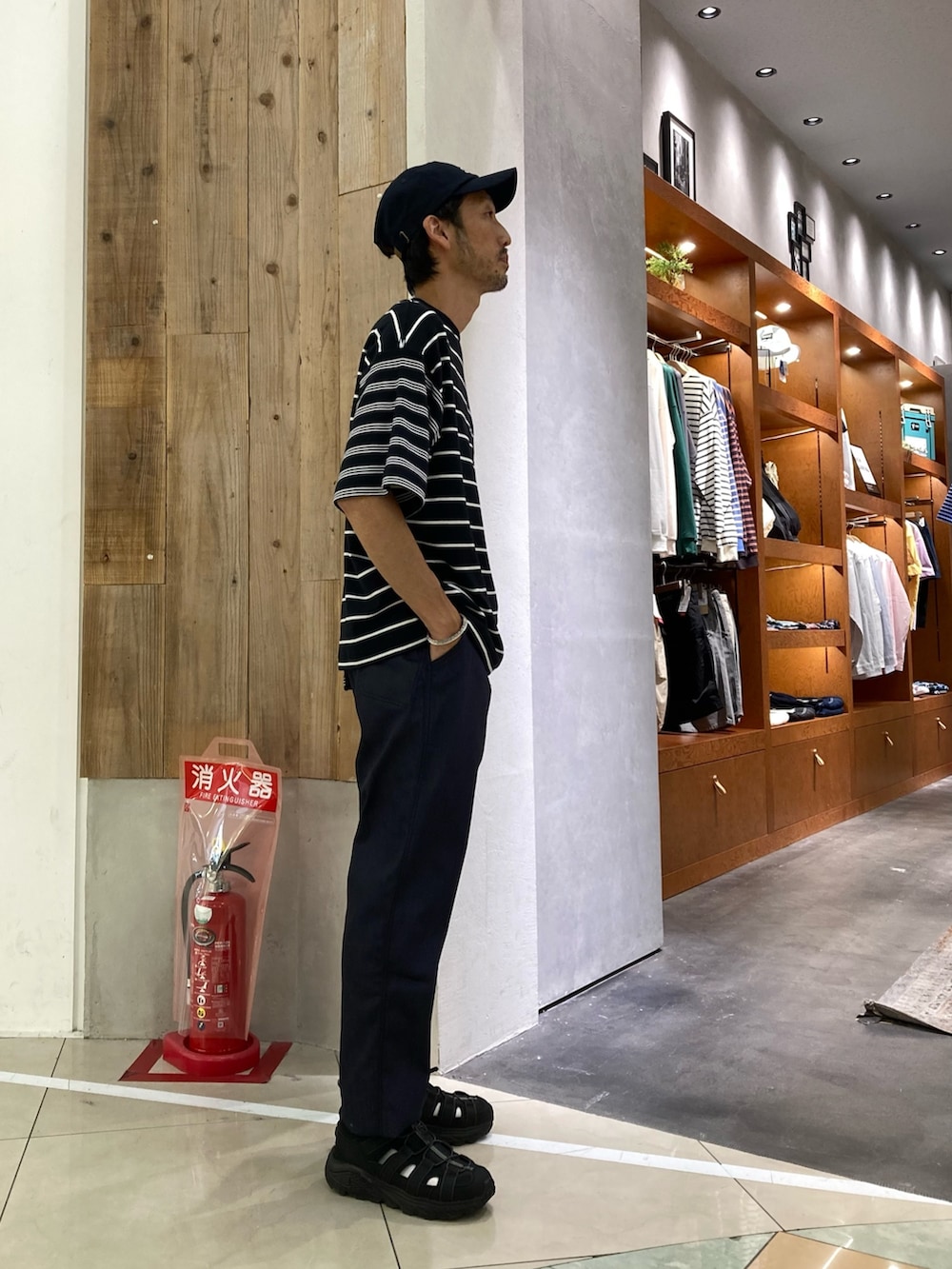 ブラック系のTシャツ/カットソー、ブルー系のデニムパンツ、ブラック系のスニーカーを着用したメンズの夏コーディネートの2枚目の写真